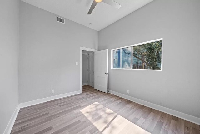 805 10th St, Galveston, TX 77550 - unfurnished bedroom featuring baseboards, high vaulted ceiling, visible vents, and wood finished floors