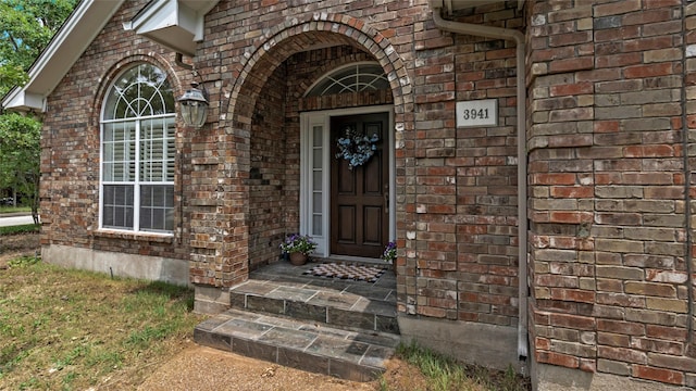 doorway to property featuring brick siding