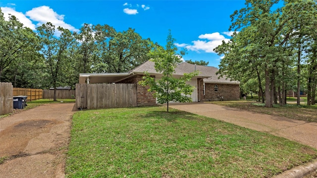 view of front of property featuring fence, a front yard, brick siding, concrete driveway, and an attached garage