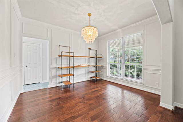 dining area featuring crown molding, a decorative wall, wood finished floors, and a notable chandelier