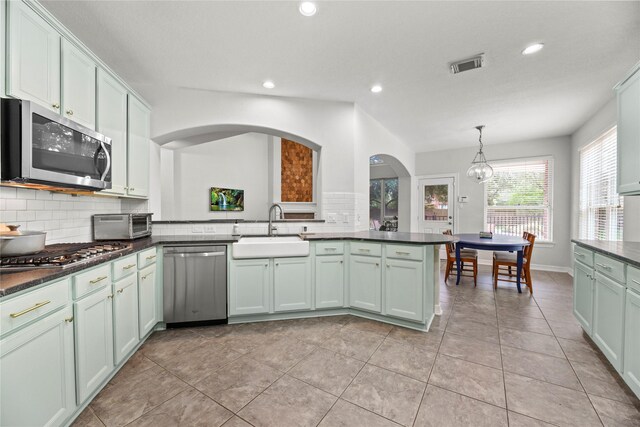 kitchen featuring dark countertops, appliances with stainless steel finishes, a sink, and visible vents