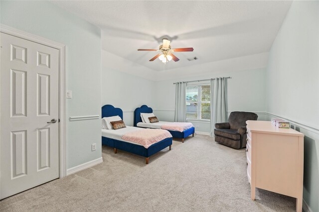 carpeted bedroom with visible vents, a ceiling fan, and baseboards