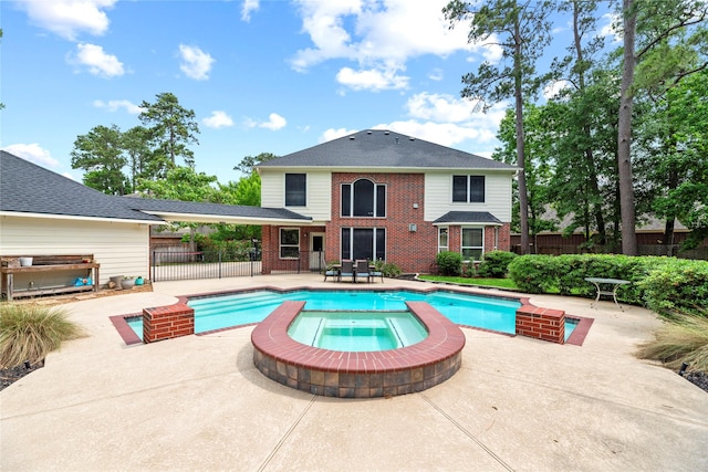 view of pool featuring a patio, a pool with connected hot tub, and fence