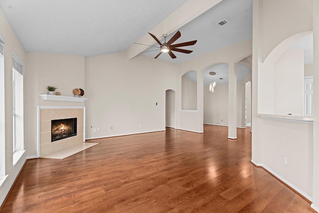 1635 Ashton Village Dr, Spring, TX 77386 - unfurnished living room with arched walkways, ceiling fan, visible vents, and vaulted ceiling with beams