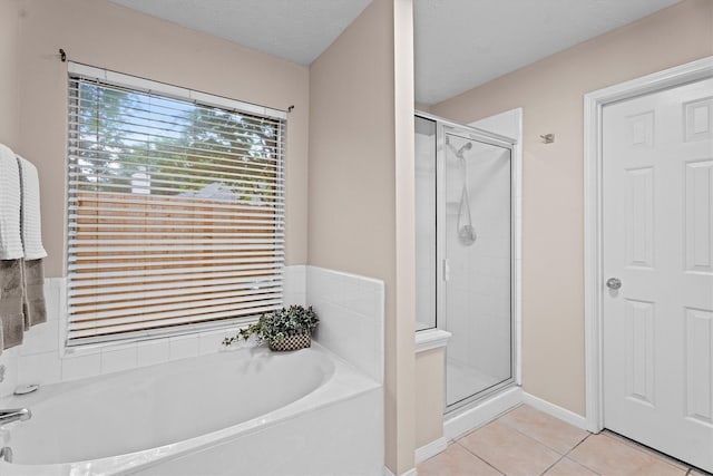 1635 Ashton Village Dr, Spring, TX 77386 - full bath featuring baseboards, tile patterned flooring, a shower stall, and a bath