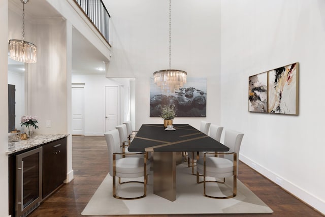 dining area featuring crown molding, beverage cooler, baseboards, dark wood-type flooring, and a notable chandelier