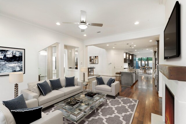 6011 Burgoyne Rd Unit A, Houston, TX 77057 - living area with ceiling fan, dark wood-type flooring, recessed lighting, crown molding, and a warm lit fireplace