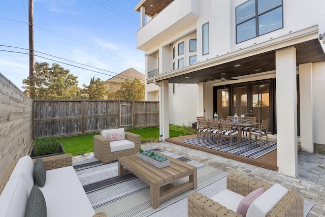 view of patio with outdoor dining area, an outdoor living space, a ceiling fan, and a fenced backyard