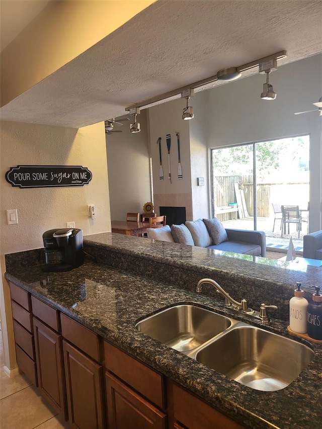 3922 Lakewood Dr, Montgomery, TX 77356 - kitchen with light tile patterned flooring, a sink, a textured ceiling, dark stone countertops, and open floor plan