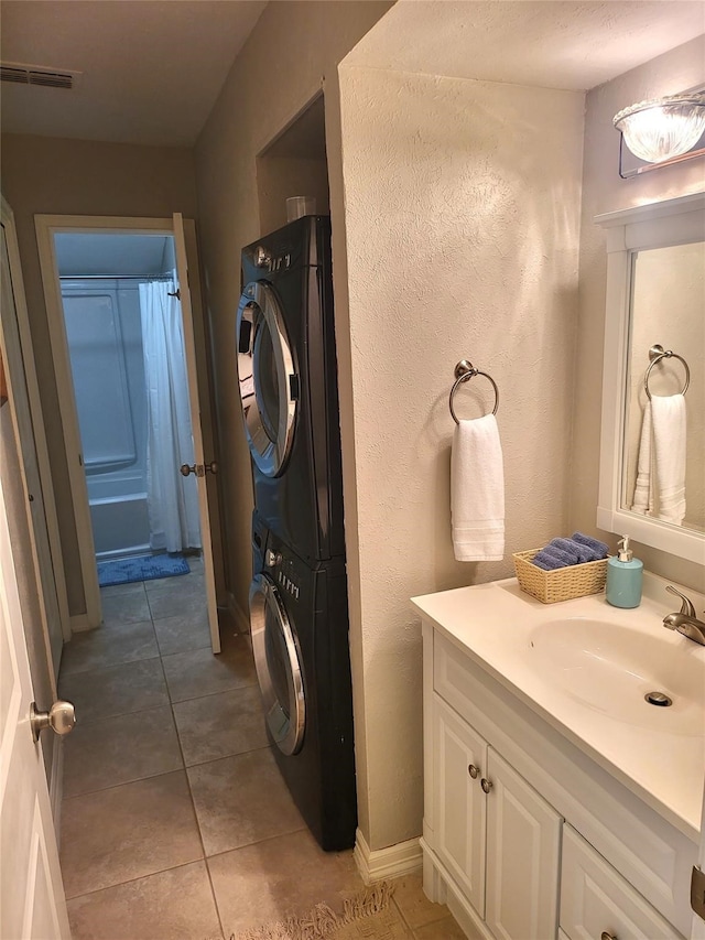 3922 Lakewood Dr, Montgomery, TX 77356 - bathroom with a textured wall, vanity, tile patterned floors, stacked washing maching and dryer, and visible vents
