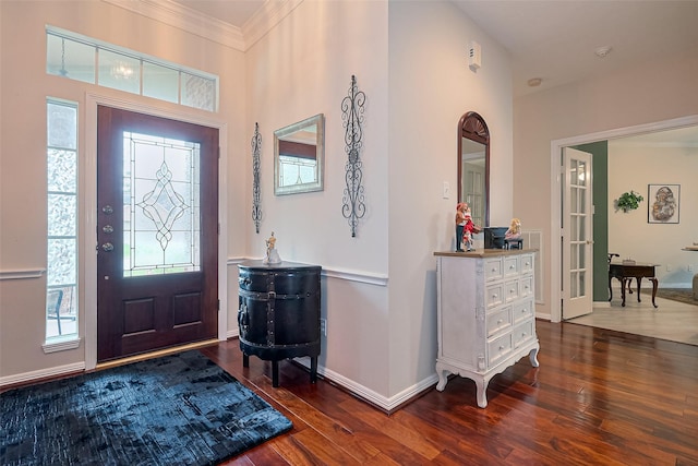 foyer with crown molding, baseboards, and wood finished floors