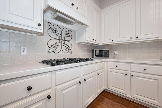 kitchen with light countertops, white cabinetry, gas stovetop, and under cabinet range hood