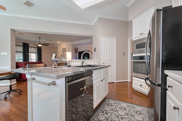 kitchen with a sink, stainless steel appliances, dark wood-style flooring, and visible vents