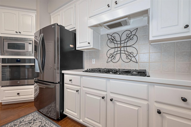 kitchen with light countertops, appliances with stainless steel finishes, white cabinets, and under cabinet range hood