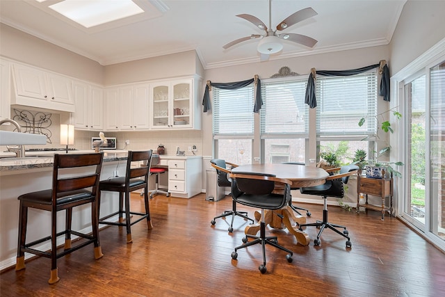 dining space featuring crown molding, a ceiling fan, and wood finished floors