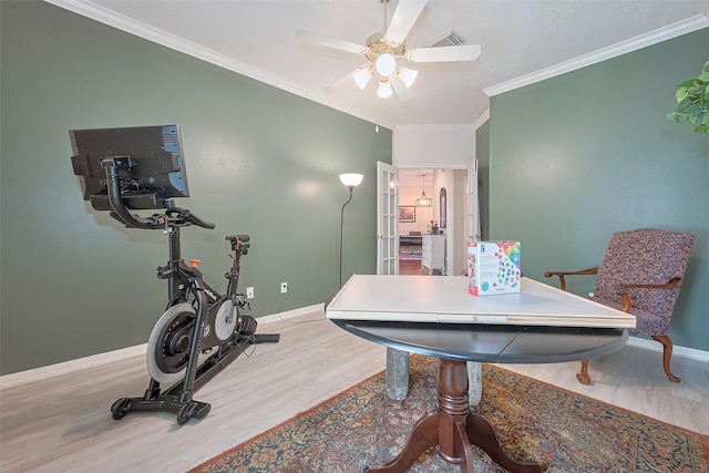 dining room with a ceiling fan, baseboards, ornamental molding, and wood finished floors