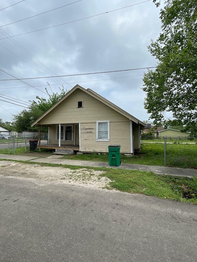 bungalow-style house with a porch and fence
