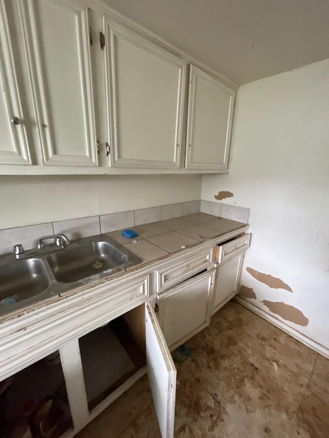 kitchen featuring tile countertops, light floors, and white cabinets