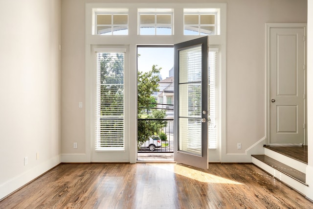 doorway to outside featuring baseboards, stairs, and wood finished floors