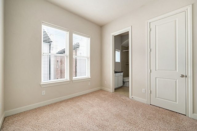 unfurnished bedroom with baseboards, multiple windows, and light carpet