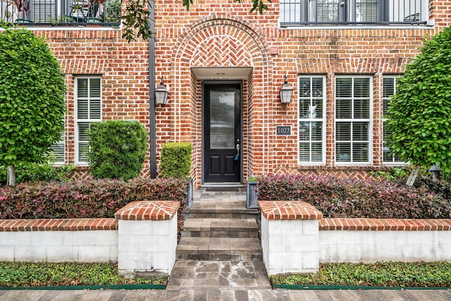 doorway to property with brick siding