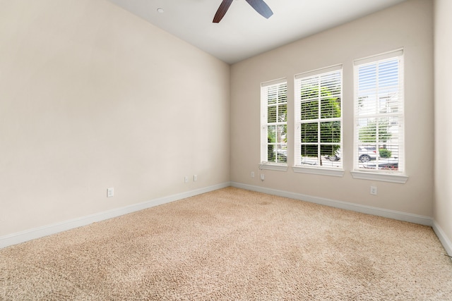 carpeted spare room with baseboards and ceiling fan