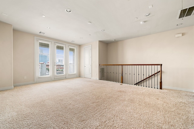 spare room featuring baseboards, carpet flooring, visible vents, and recessed lighting