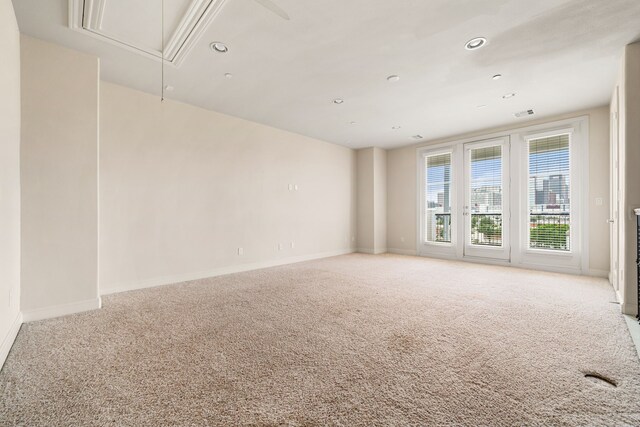 carpeted empty room featuring recessed lighting, baseboards, visible vents, and attic access