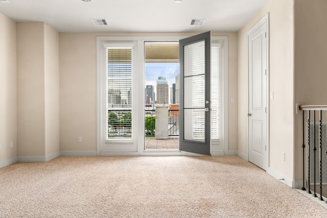 carpeted empty room with visible vents and baseboards