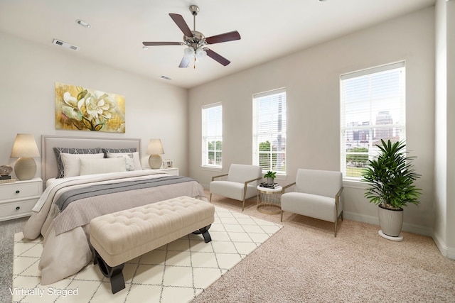 bedroom with baseboards, light carpet, and visible vents