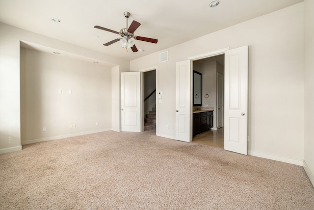 unfurnished bedroom with visible vents, baseboards, ensuite bath, and light colored carpet