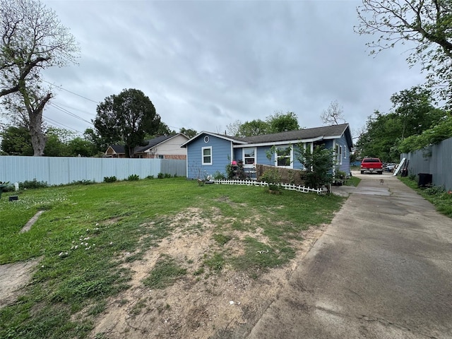 5526 Bunte St, Houston, TX 77026 - view of front facade with fence, driveway, and a front lawn
