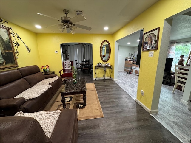5526 Bunte St, Houston, TX 77026 - living room featuring arched walkways, ceiling fan, visible vents, and dark wood-type flooring