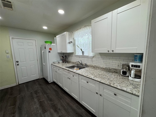 5526 Bunte St, Houston, TX 77026 - kitchen featuring a sink, white cabinets, backsplash, and dark wood-style floors