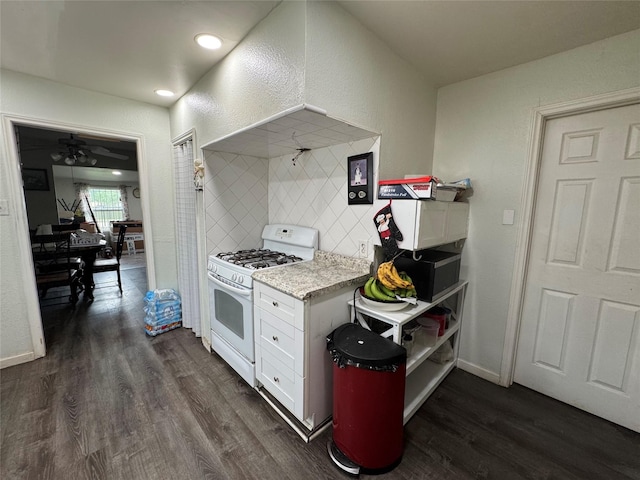 5526 Bunte St, Houston, TX 77026 - kitchen featuring white gas range, dark wood finished floors, baseboards, white cabinets, and a textured wall