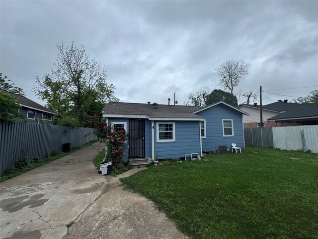 5526 Bunte St, Houston, TX 77026 - rear view of property featuring a yard, fence private yard, and driveway