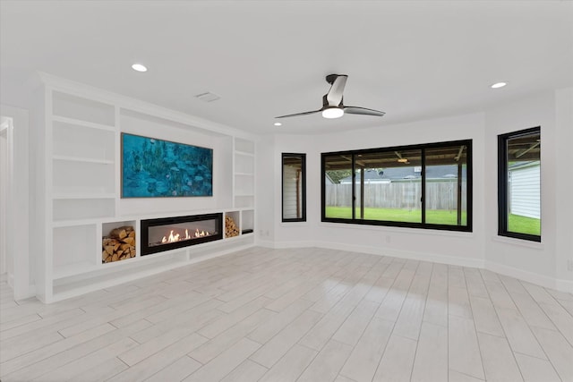 2611 Teague Rd, Houston, TX 77080 - unfurnished living room featuring wood finished floors, a ceiling fan, built in features, baseboards, and a glass covered fireplace