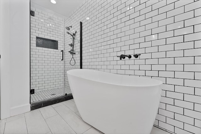 2611 Teague Rd, Houston, TX 77080 - bathroom featuring tile walls, tile patterned floors, a stall shower, recessed lighting, and a freestanding tub