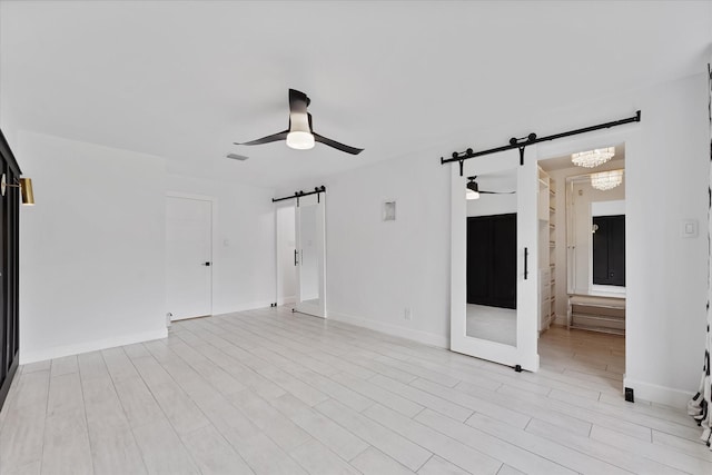 2611 Teague Rd, Houston, TX 77080 - spare room featuring baseboards, a barn door, a ceiling fan, and visible vents