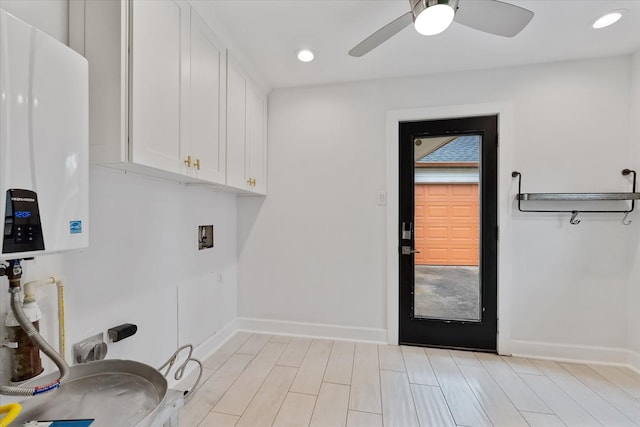 2611 Teague Rd, Houston, TX 77080 - clothes washing area featuring cabinet space, tankless water heater, baseboards, and a ceiling fan