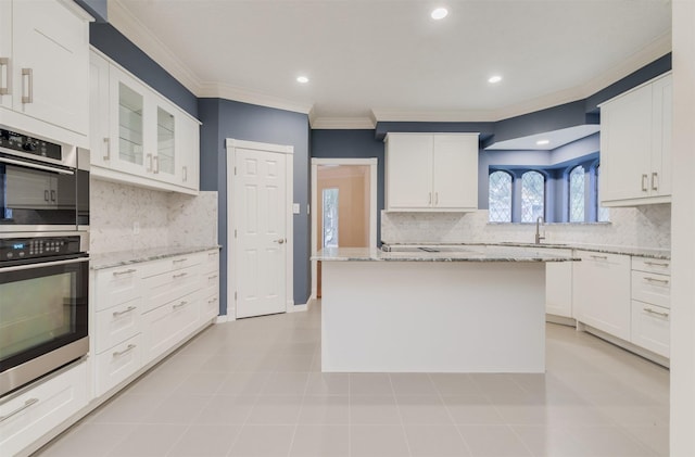 714 Last Arrow Dr, Houston, TX 77079 - kitchen with crown molding, a sink, double oven, tasteful backsplash, and white cabinets
