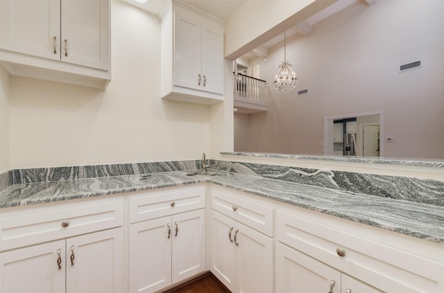 714 Last Arrow Dr, Houston, TX 77079 - kitchen featuring beamed ceiling, light stone counters, a chandelier, stainless steel fridge with ice dispenser, and white cabinets