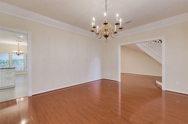 714 Last Arrow Dr, Houston, TX 77079 - spare room with a chandelier, wood finished floors, ornamental molding, baseboards, and stairway
