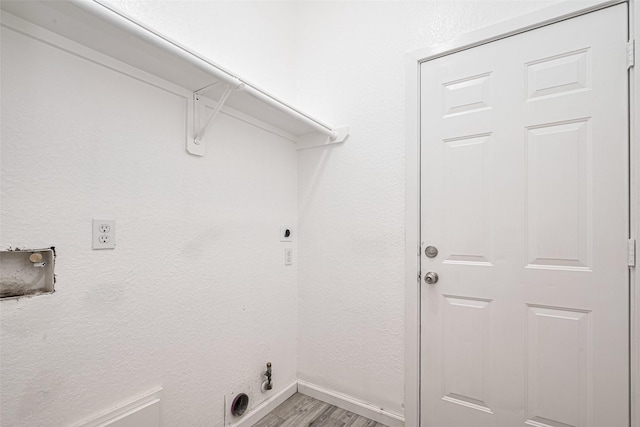 washroom with laundry area, baseboards, hookup for an electric dryer, light wood finished floors, and hookup for a gas dryer