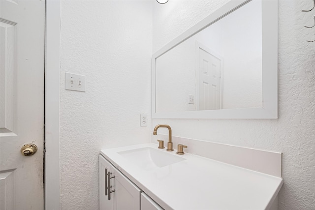 bathroom featuring vanity and a textured wall