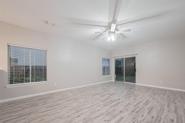 spare room with a ceiling fan, baseboards, visible vents, and light wood finished floors