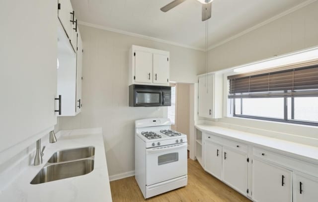 219 W 13th St, Houston, TX 77008 - kitchen with white cabinets, black microwave, a sink, white range with gas cooktop, and ornamental molding