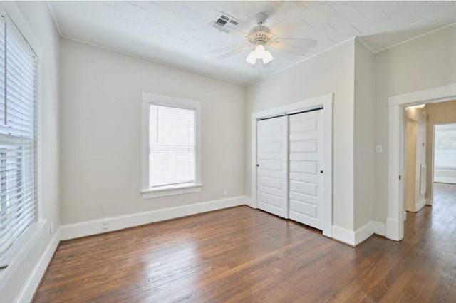219 W 13th St, Houston, TX 77008 - unfurnished bedroom featuring crown molding, baseboards, dark wood-style flooring, and visible vents