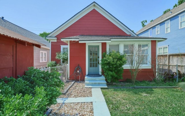219 W 13th St, Houston, TX 77008 - view of front of property featuring a shingled roof, fence, and a front yard