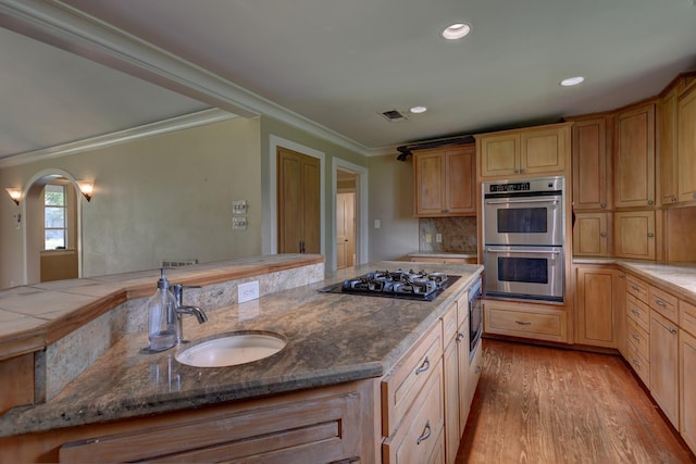 708 4th St, Sealy, TX 77474 - kitchen featuring double oven, black gas stovetop, crown molding, light wood-style floors, and a sink